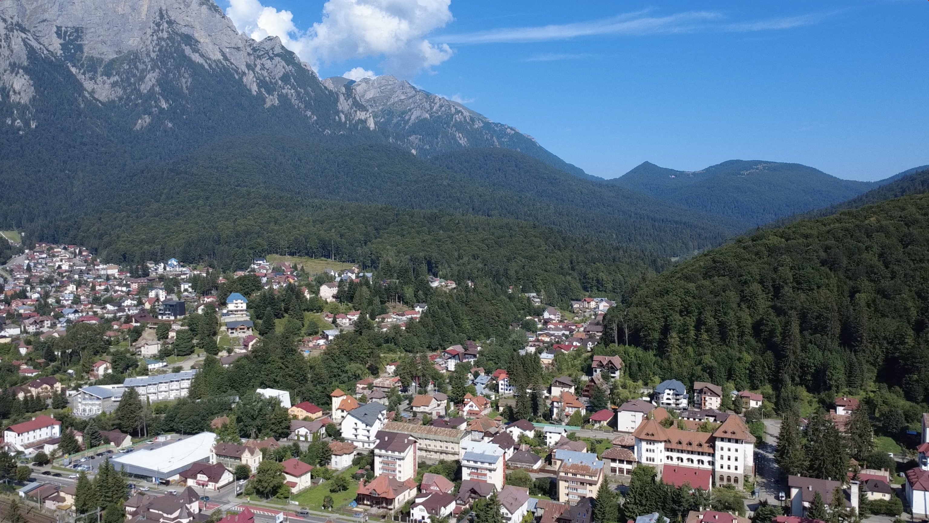 Bușteni văzut din dronă, cu orașul și muntele în fundal